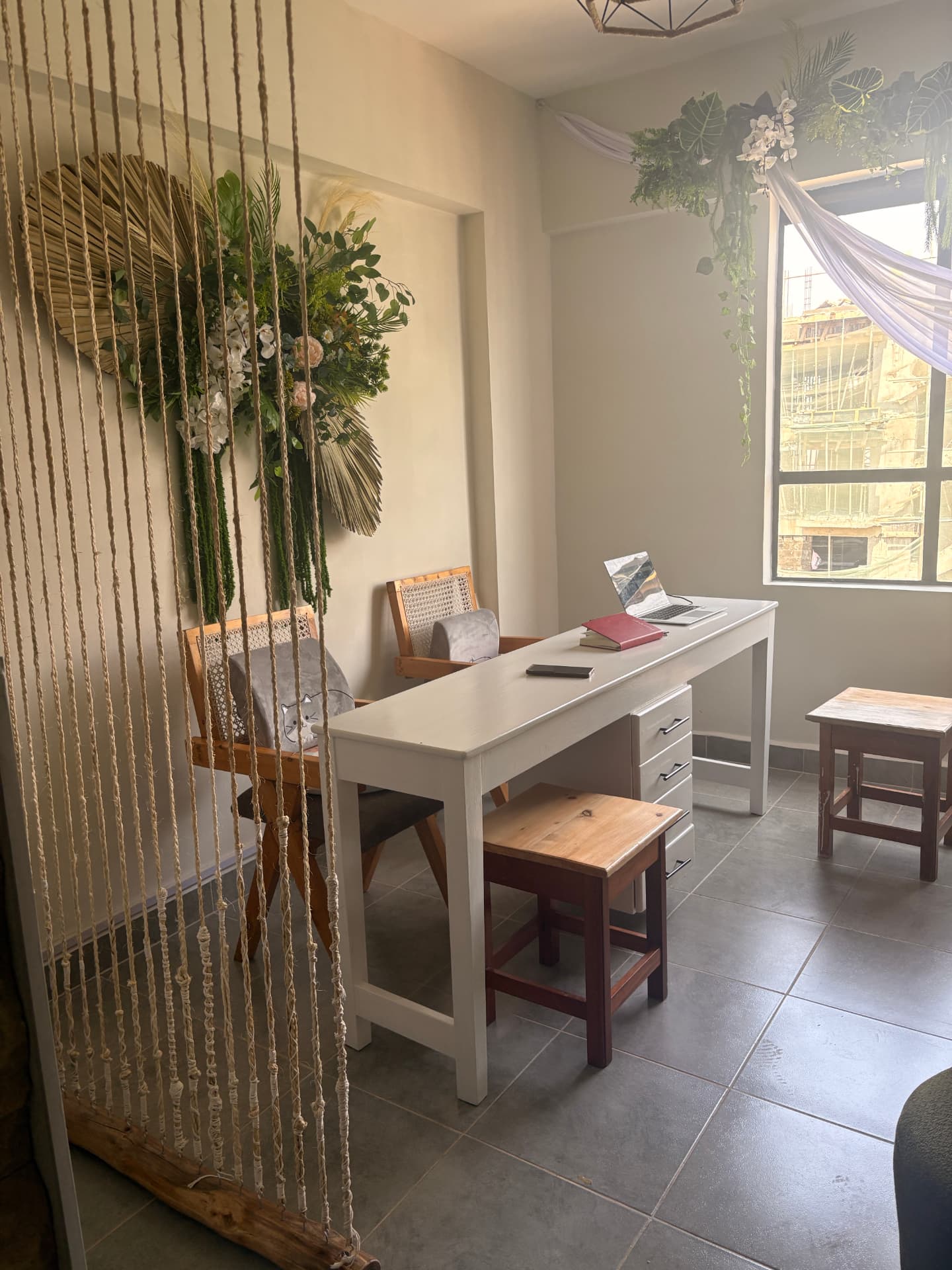 Reception desk at Kiki's mini spa framed by dried palm and floral wall art